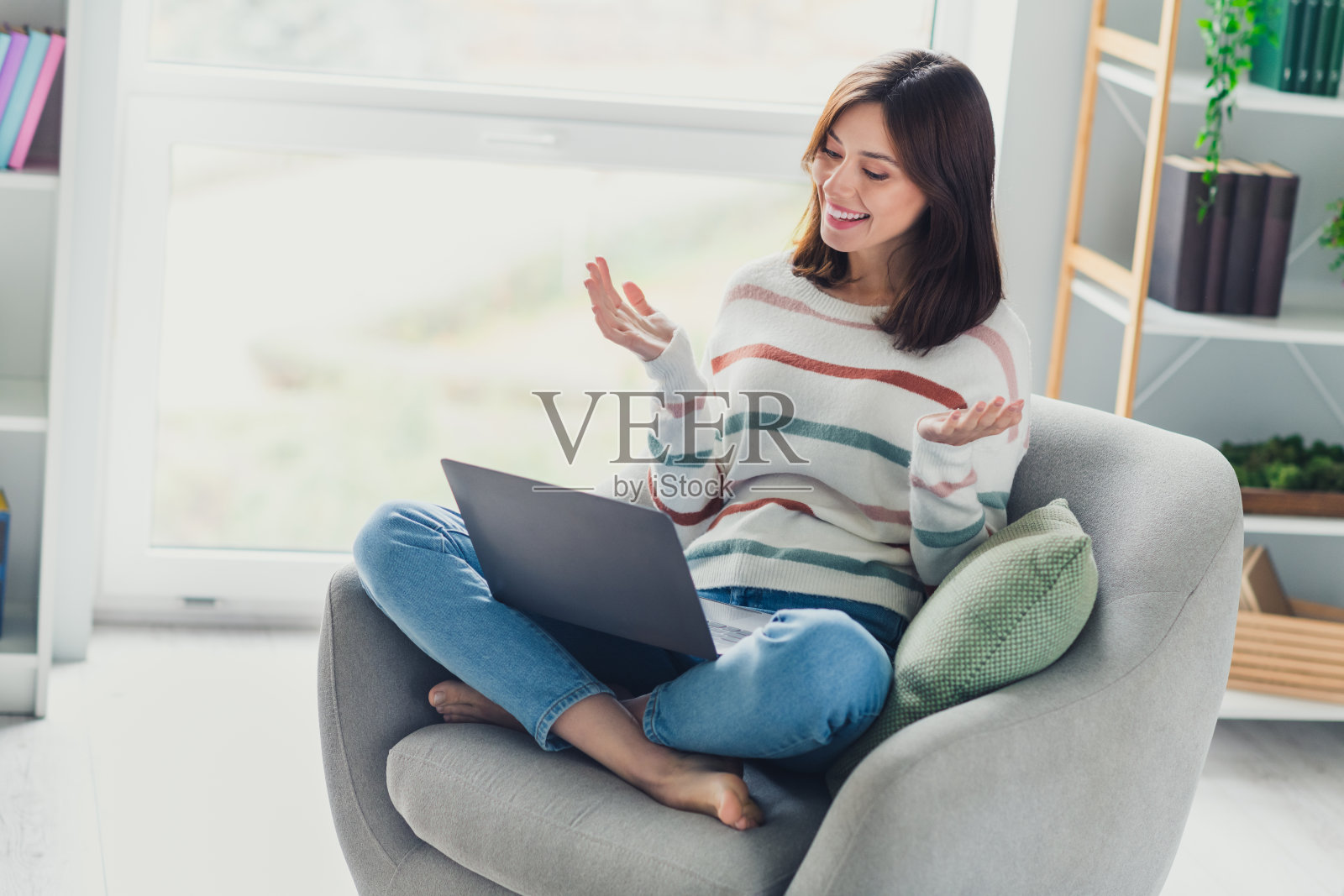 迷人的开朗女孩的全尺寸肖像坐在光脚椅子上交流视频通话笔记本电脑明亮的室内平面照片摄影图片