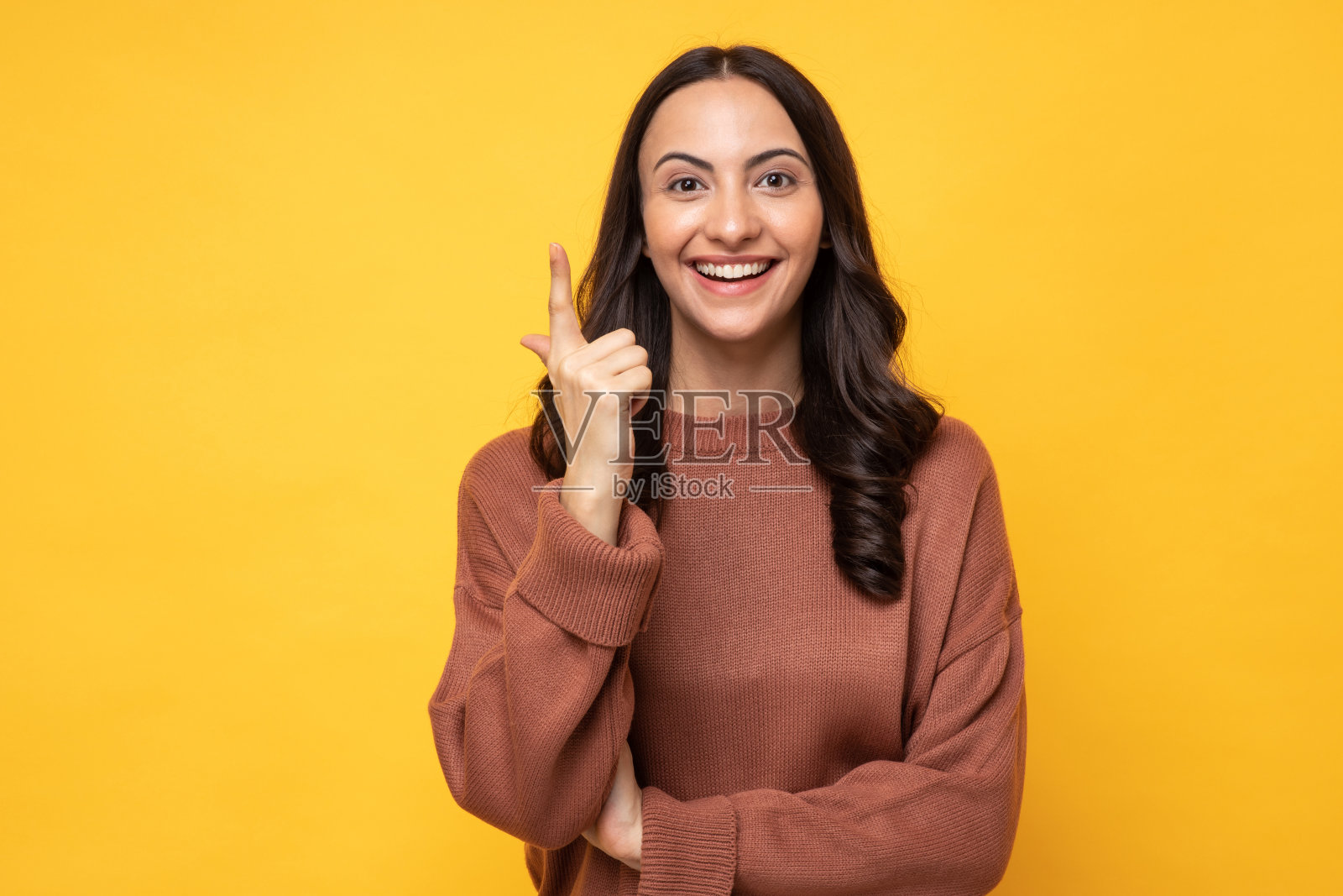 照片的年轻妇女在冬天穿站在黄色背景股票照片照片摄影图片