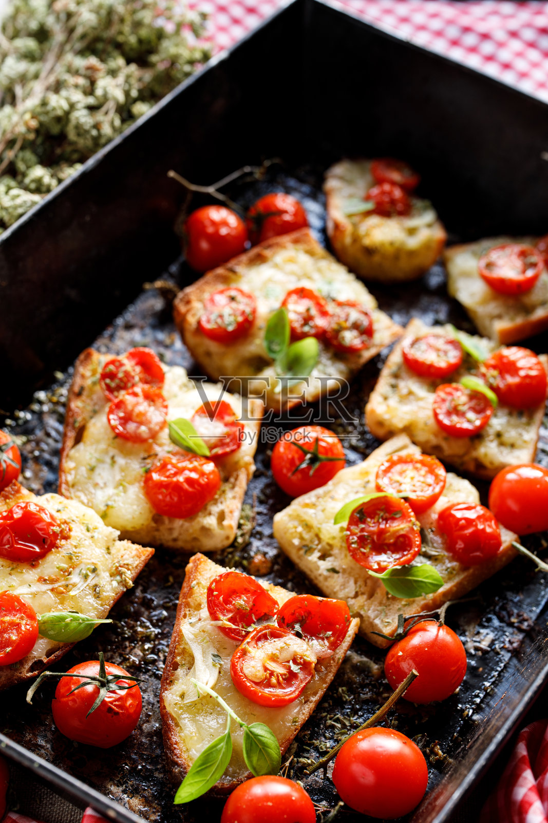 烤面包，法棍面包，马苏里拉奶酪和圣女果调味香草在烤盘，特写照片摄影图片
