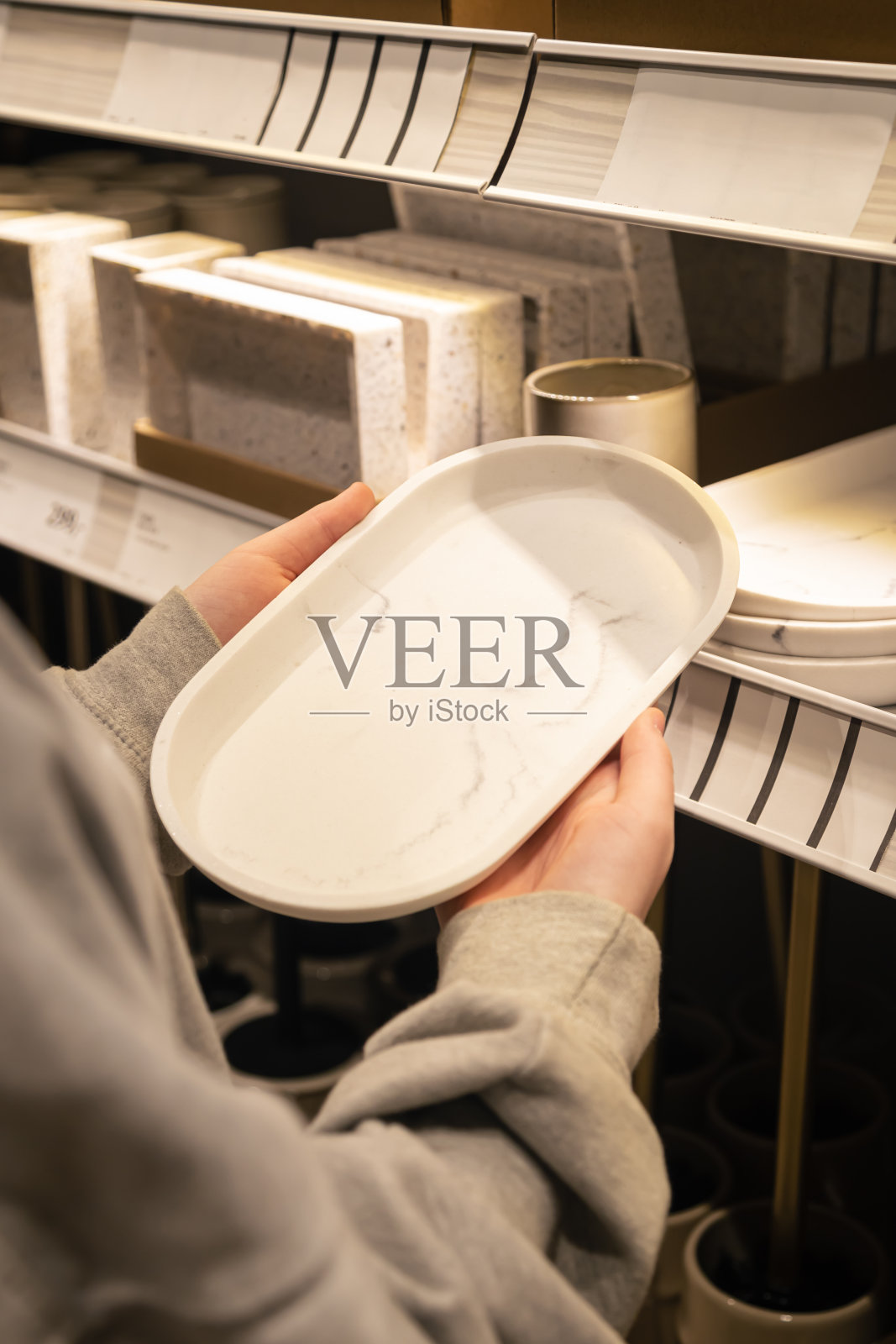 女人拿着盘子在店里，概念地选菜。照片摄影图片