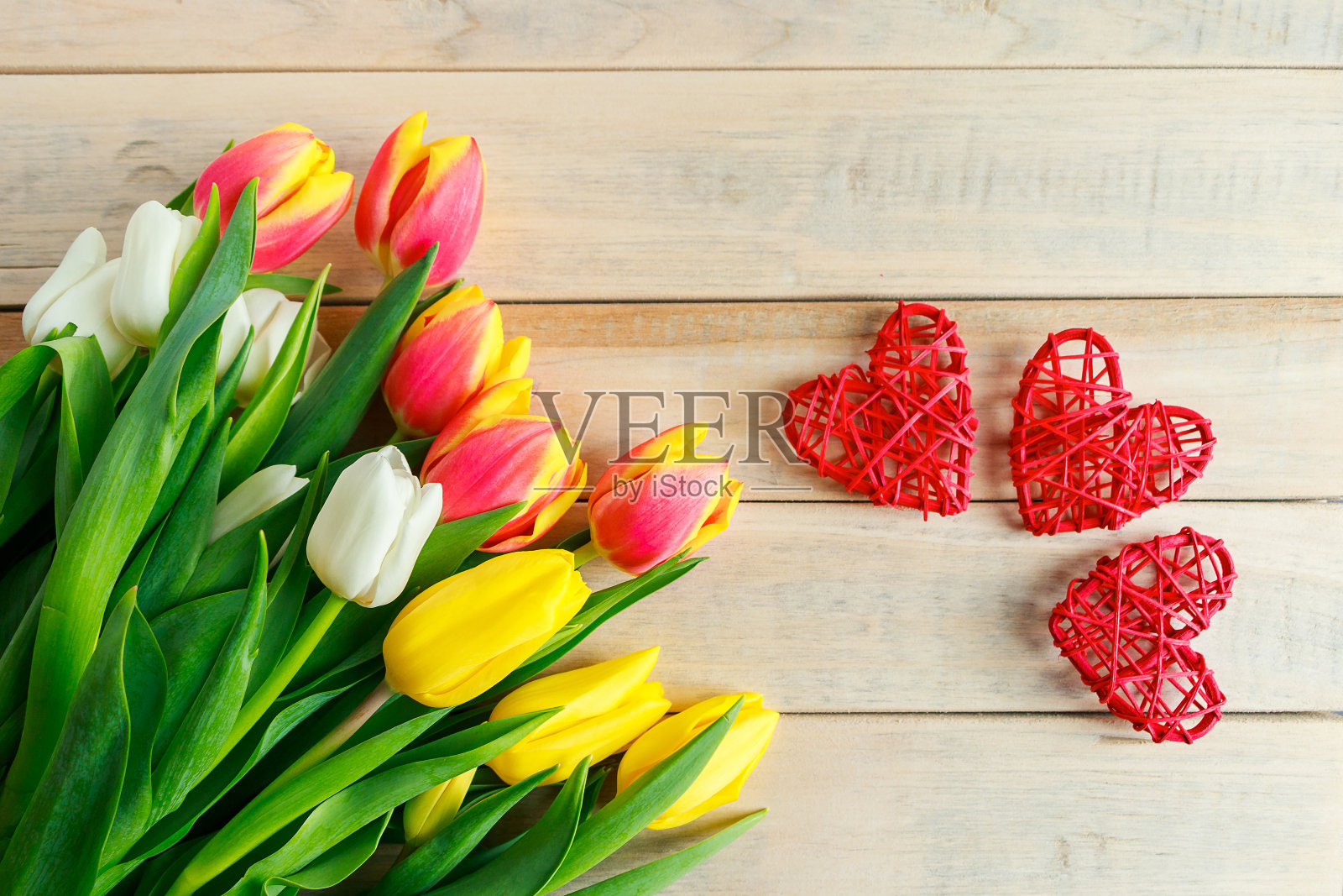 木制背景上的郁金香和心形图案。情人节贺卡概念。照片摄影图片
