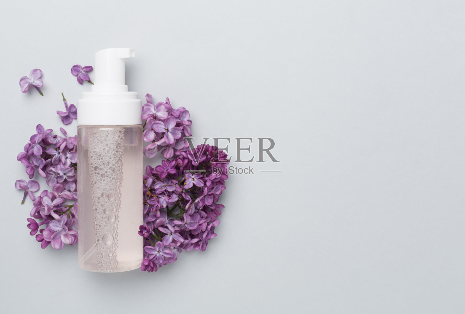 泡沫洗面奶和花的颜色背景，俯视图照片摄影图片