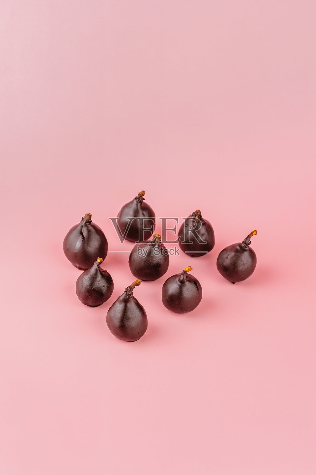 用巧克力和坚果在粉色背景上手工制作的巧克力照片摄影图片