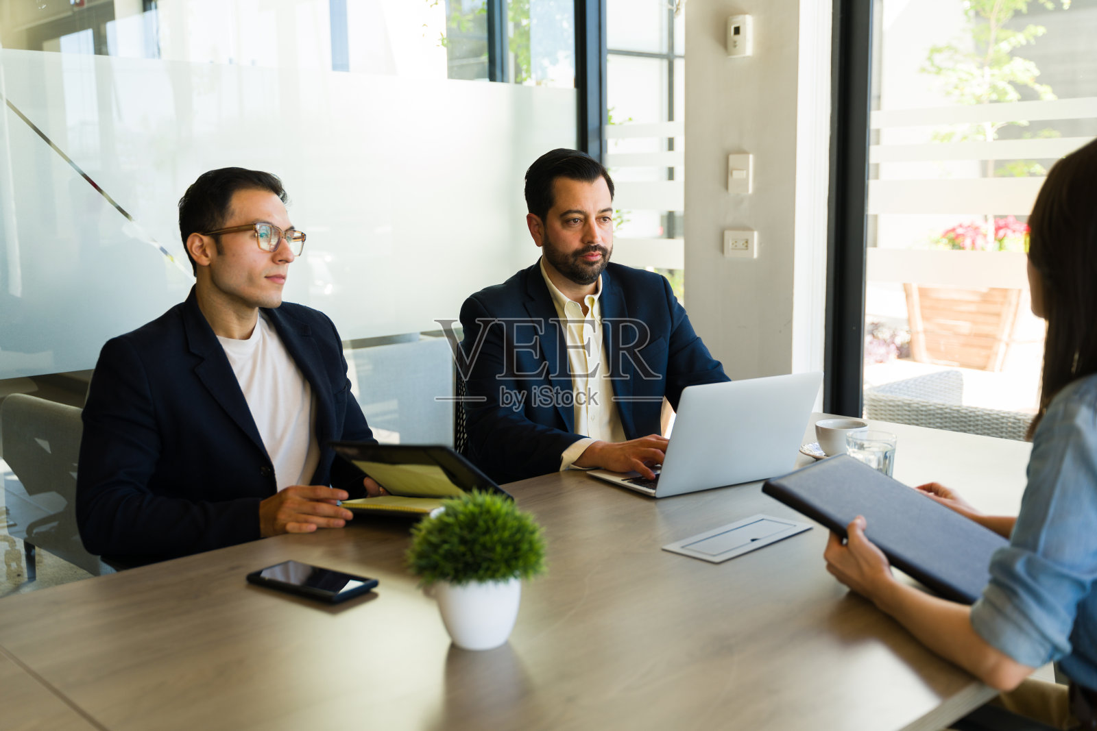 招聘人员在会议室里面试一位女商人照片摄影图片