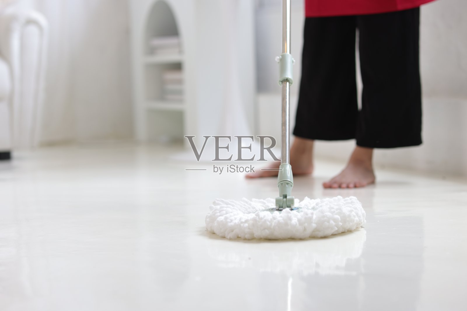 清洁工正在家里用拖把拖地。照片摄影图片