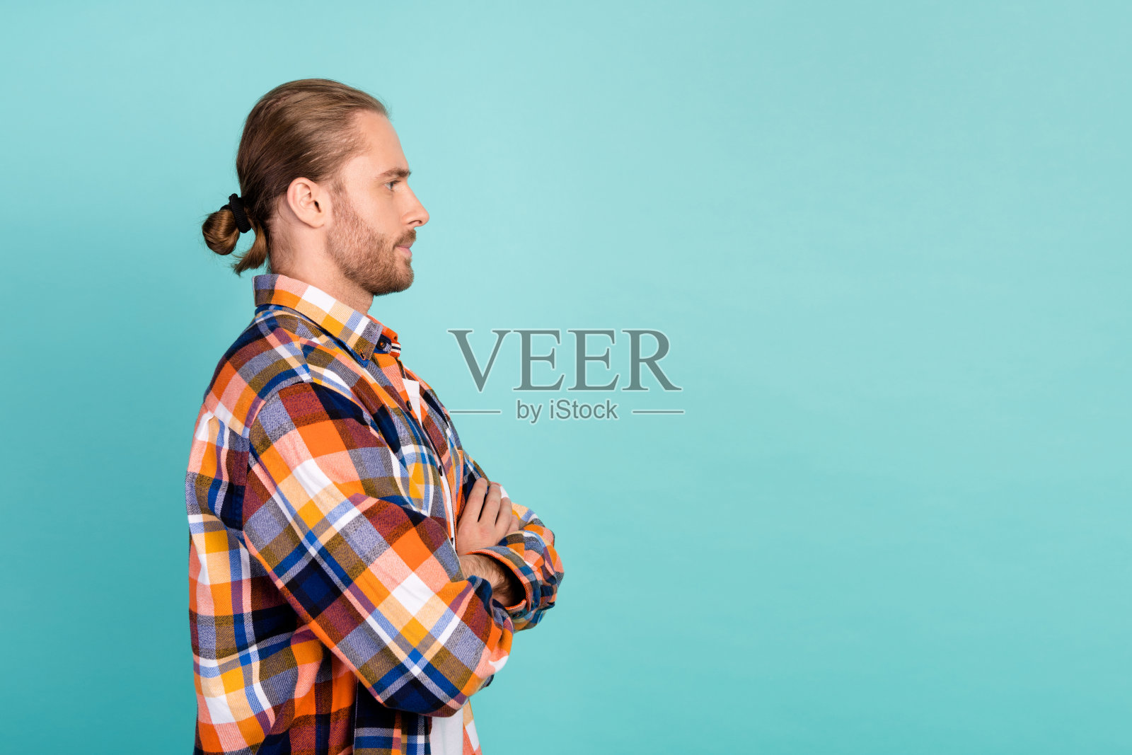 侧面侧面照片的野蛮男子与长头发穿着格子衬衫手臂交叉看空空间孤立在蓝绿色的背景照片摄影图片