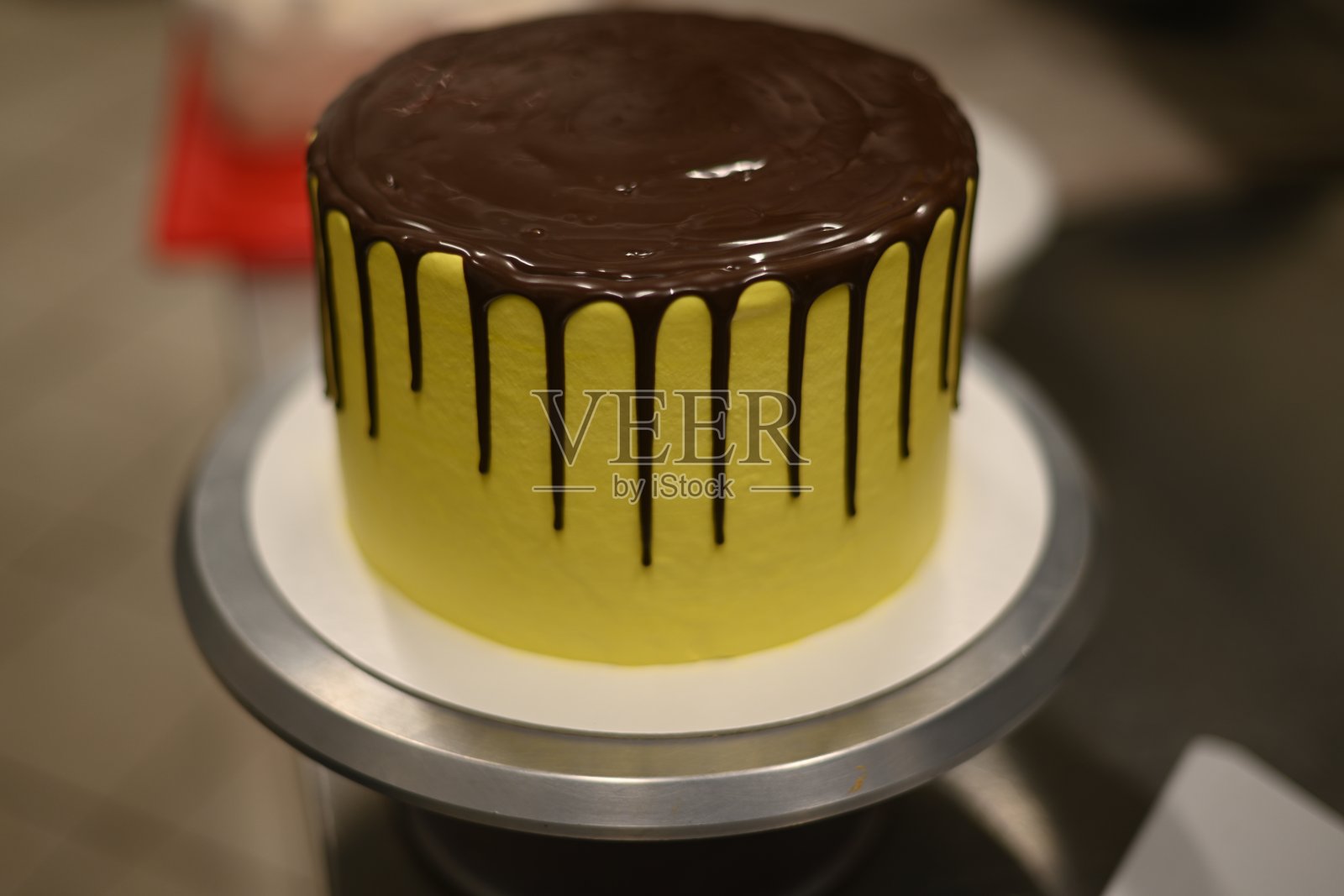 糕点师傅光滑地准备造型金黄滴霜层叠华丽的黑巧克力蛋糕照片摄影图片