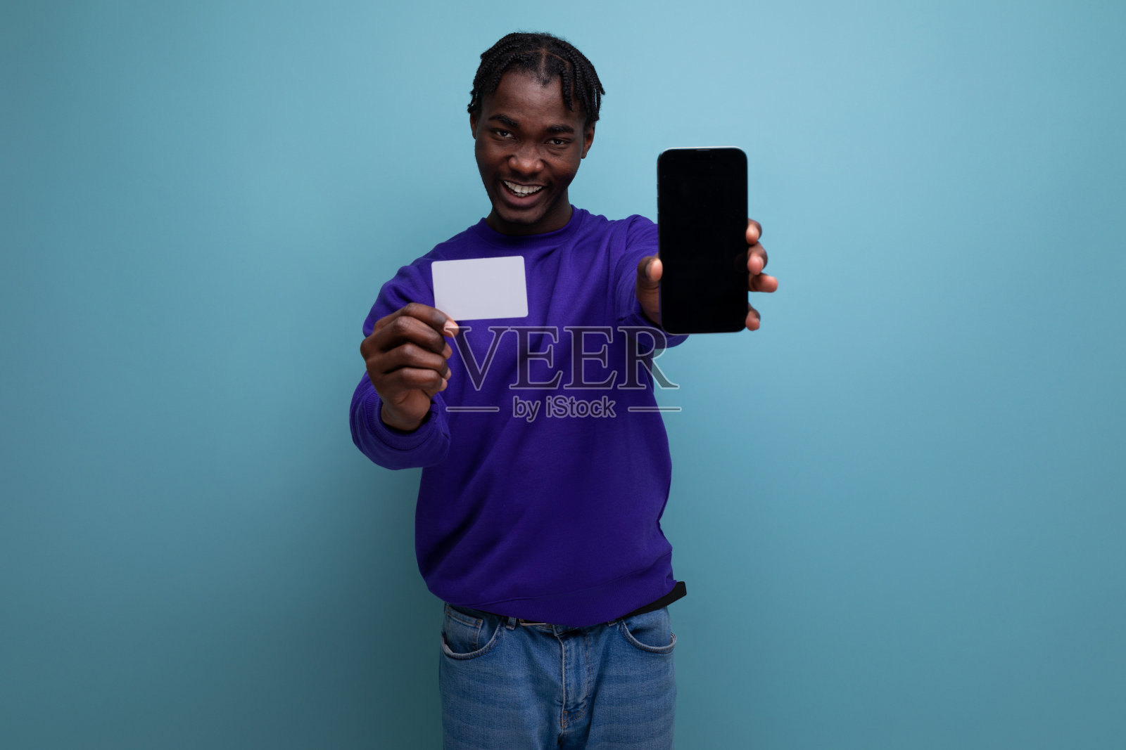 留着脏辫的美国年轻黑发男性拿着卡片和智能手机模型去购物照片摄影图片