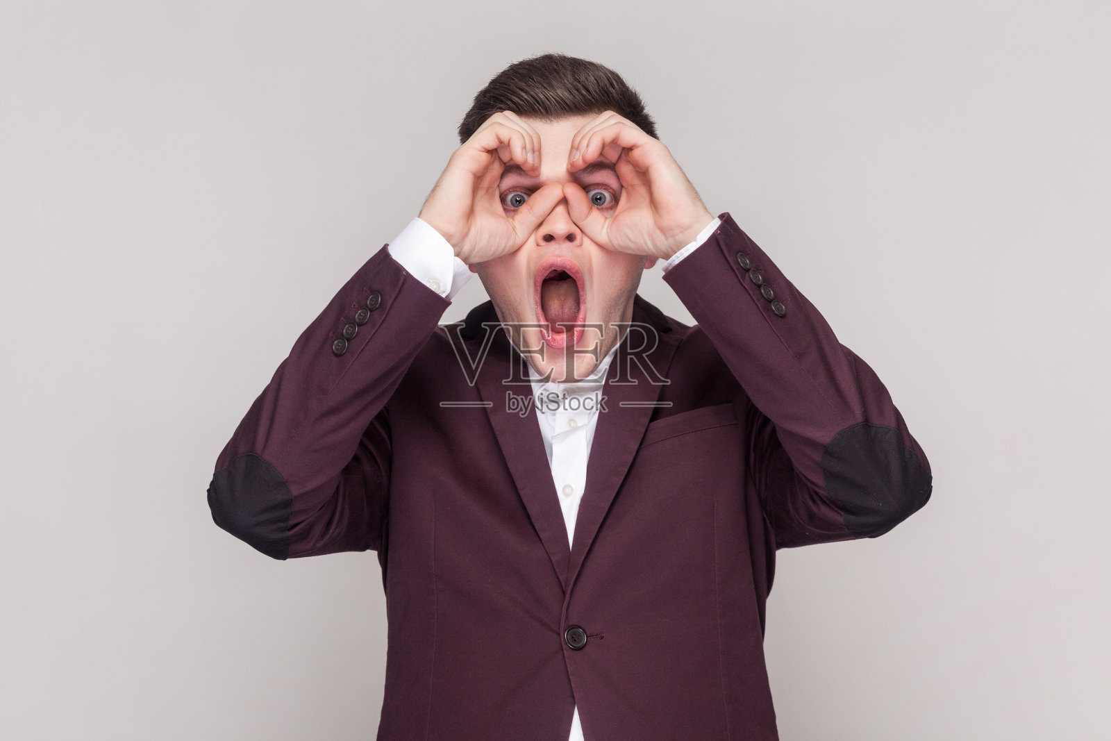 男人用双筒望远镜看，表示惊讶，放大视野。照片摄影图片