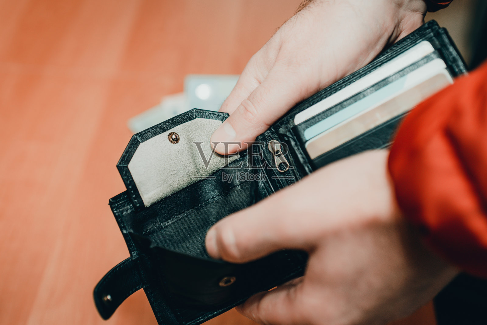 破产。商务人士拿着一个空钱包在家里，拉近色调的形象。有选择性的重点。照片摄影图片