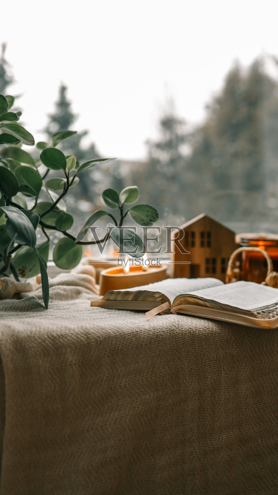 舒适的冬季照片，一叠毛衣，打开圣经，茶和蜡烛照片摄影图片