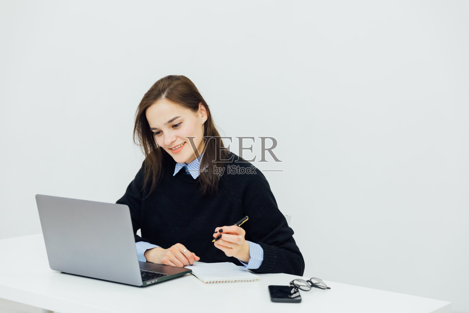 女商人在办公室用笔记本电脑做网上金融照片摄影图片