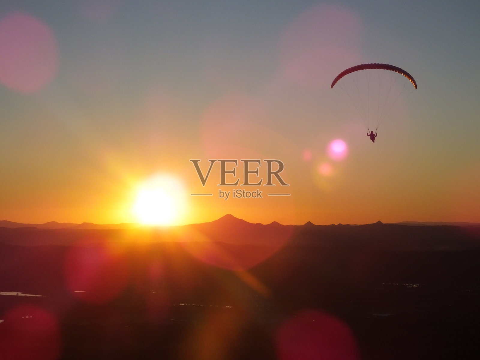 日落时天空中的滑翔伞照片摄影图片