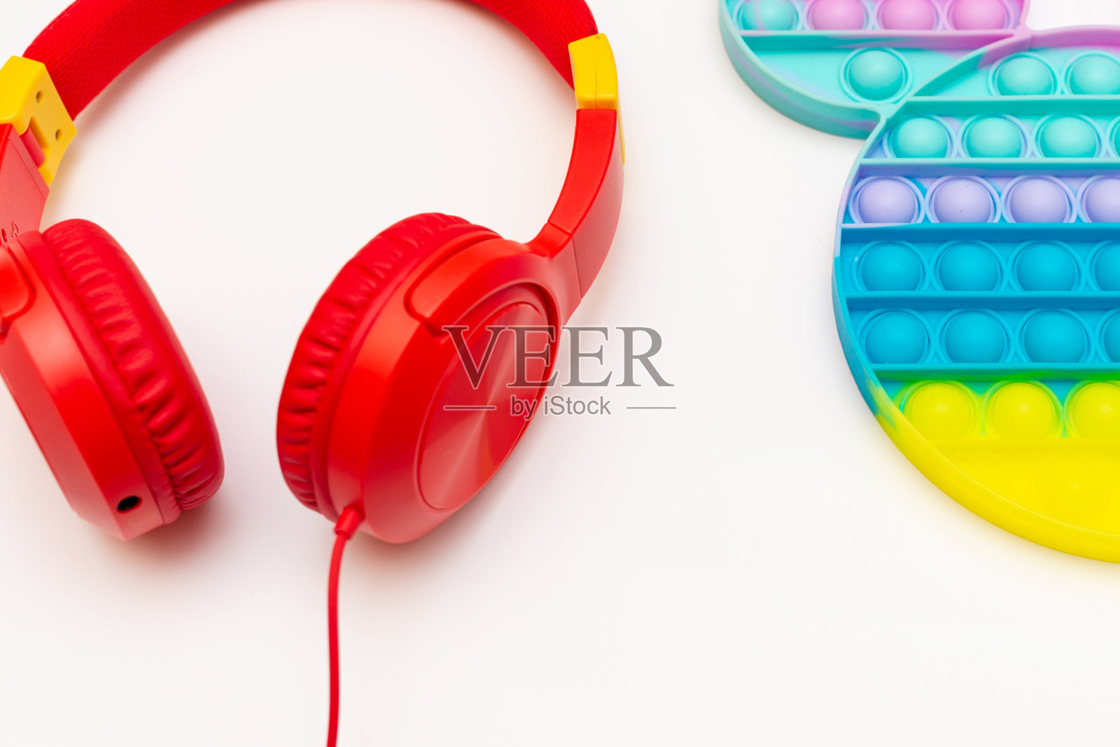 时尚硅胶感官玩具抗压力流行。抗压力玩具烦躁和耳机在白色背景。照片摄影图片