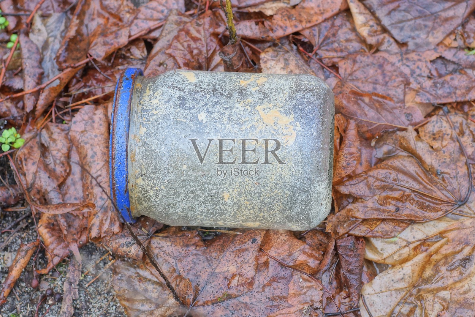 一个脏兮兮的灰色小玻璃瓶里的垃圾照片摄影图片