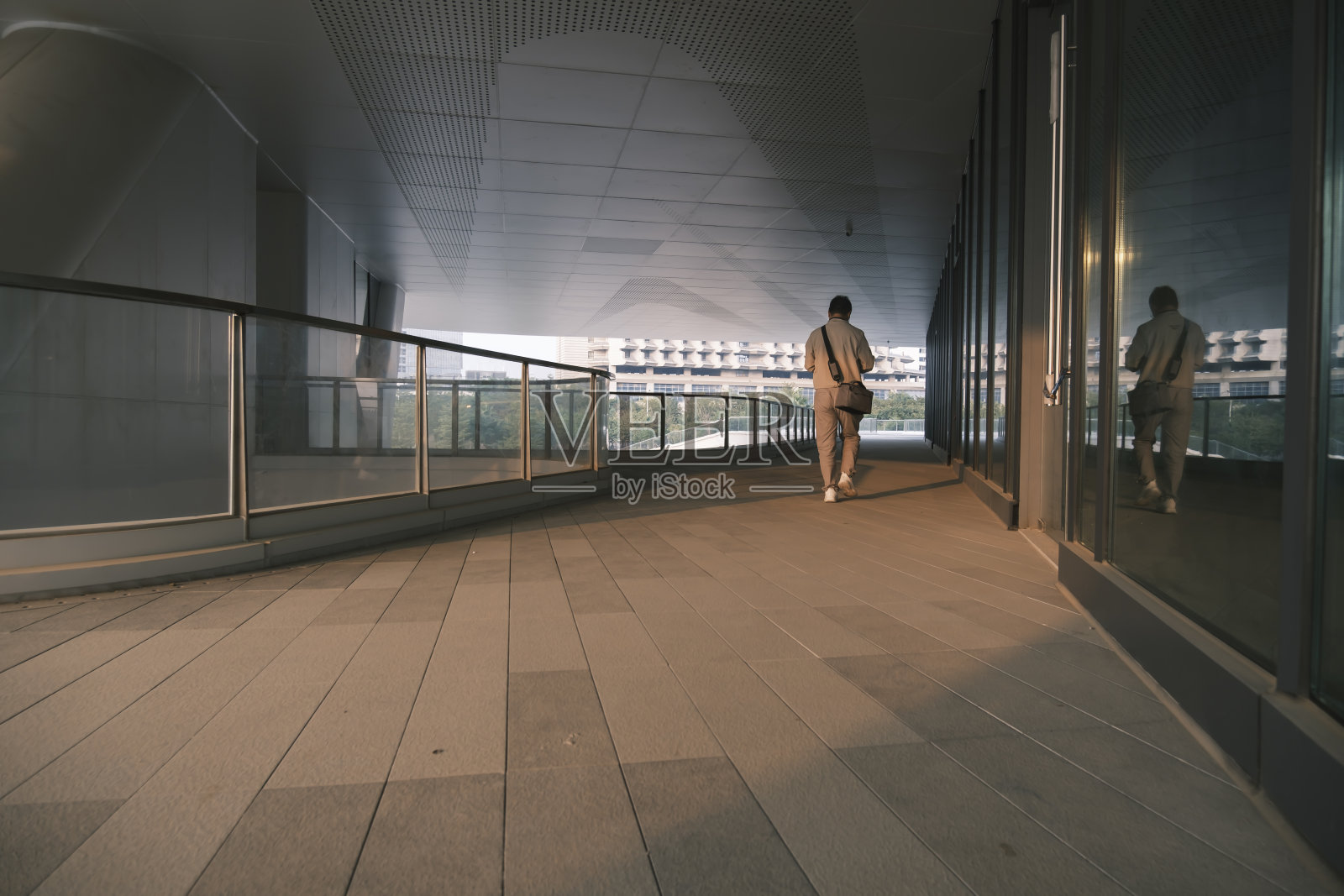 男职员走在办公楼下面的走廊里照片摄影图片