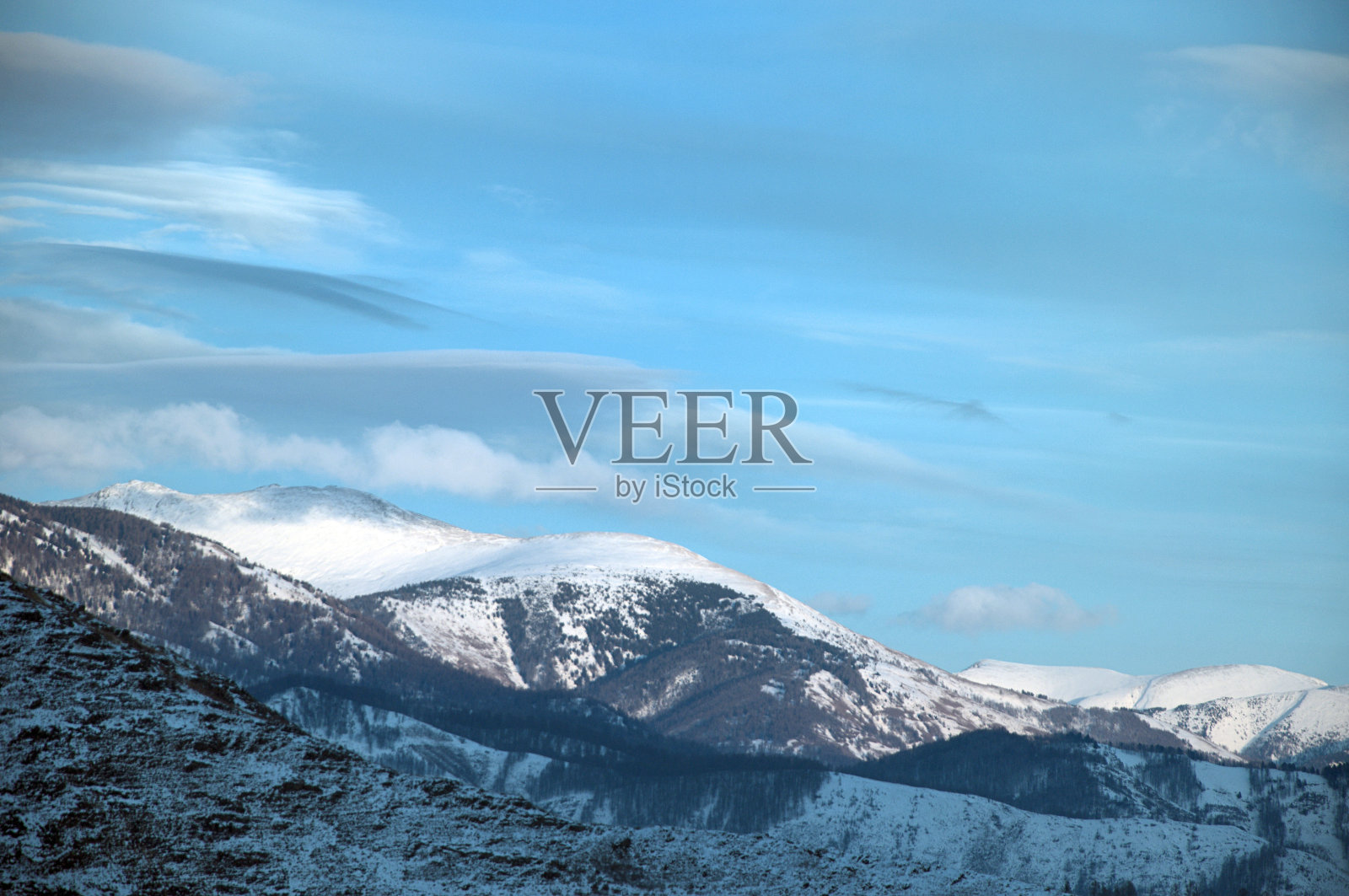 日落时寒冷的雪山景观。照片摄影图片