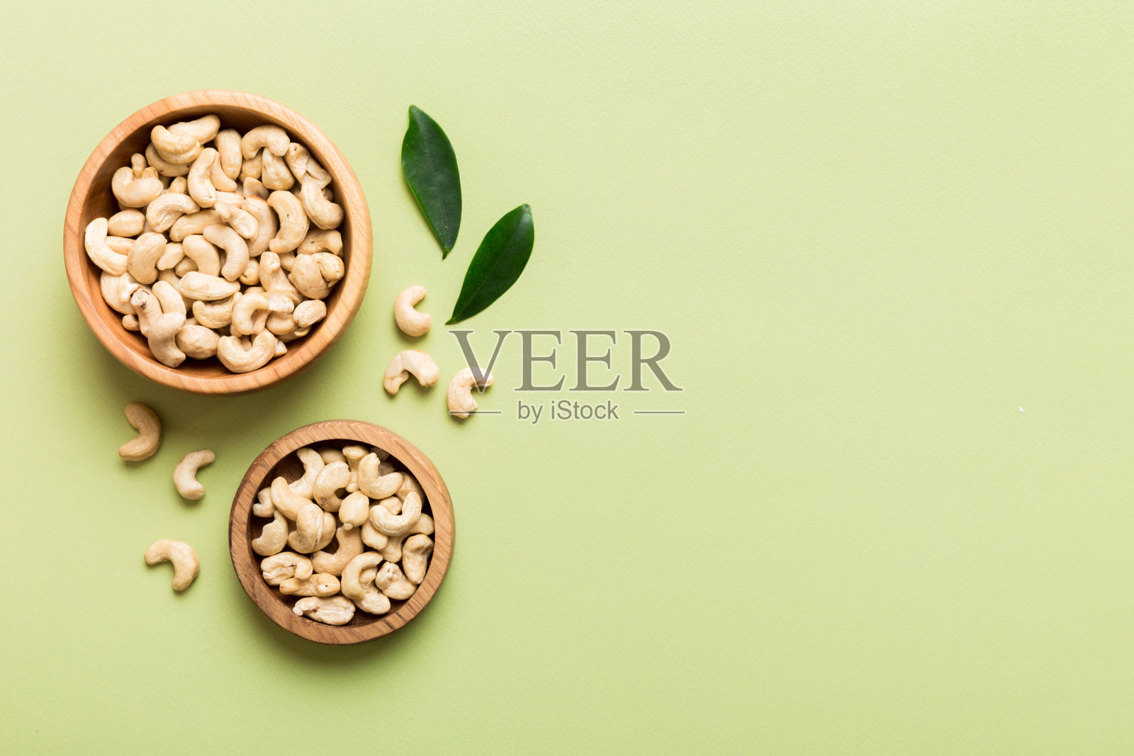 餐桌背景上木碗里的腰果。前视图。健康食品照片摄影图片