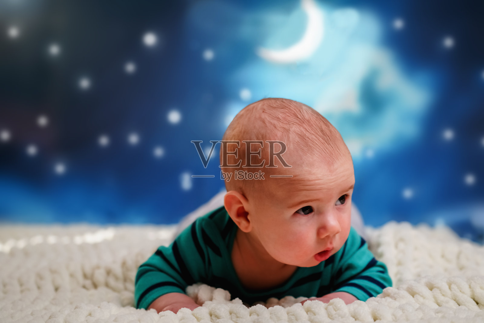 睡觉时间到了，畅想梦想概念。4个月大的宝宝躺在床上，夜空为背景。副本的空间。照片摄影图片