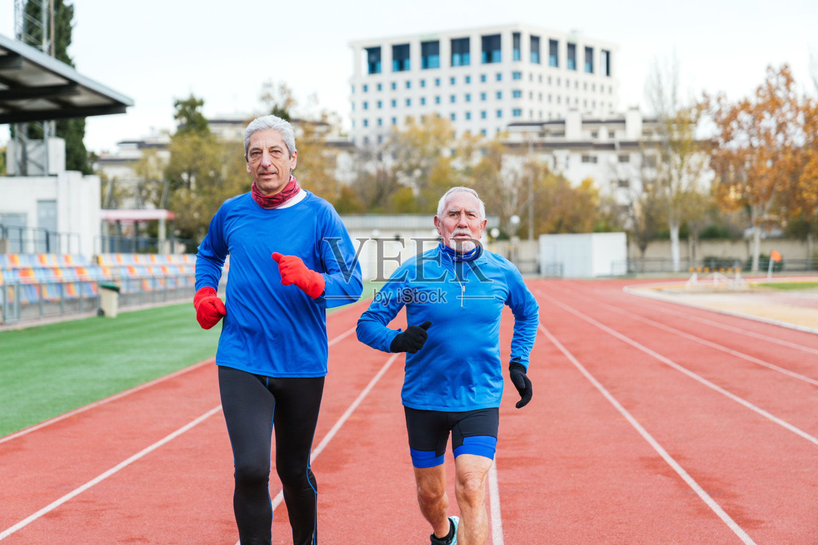 年长的白人男性运动员在田径场上一起锻炼照片摄影图片
