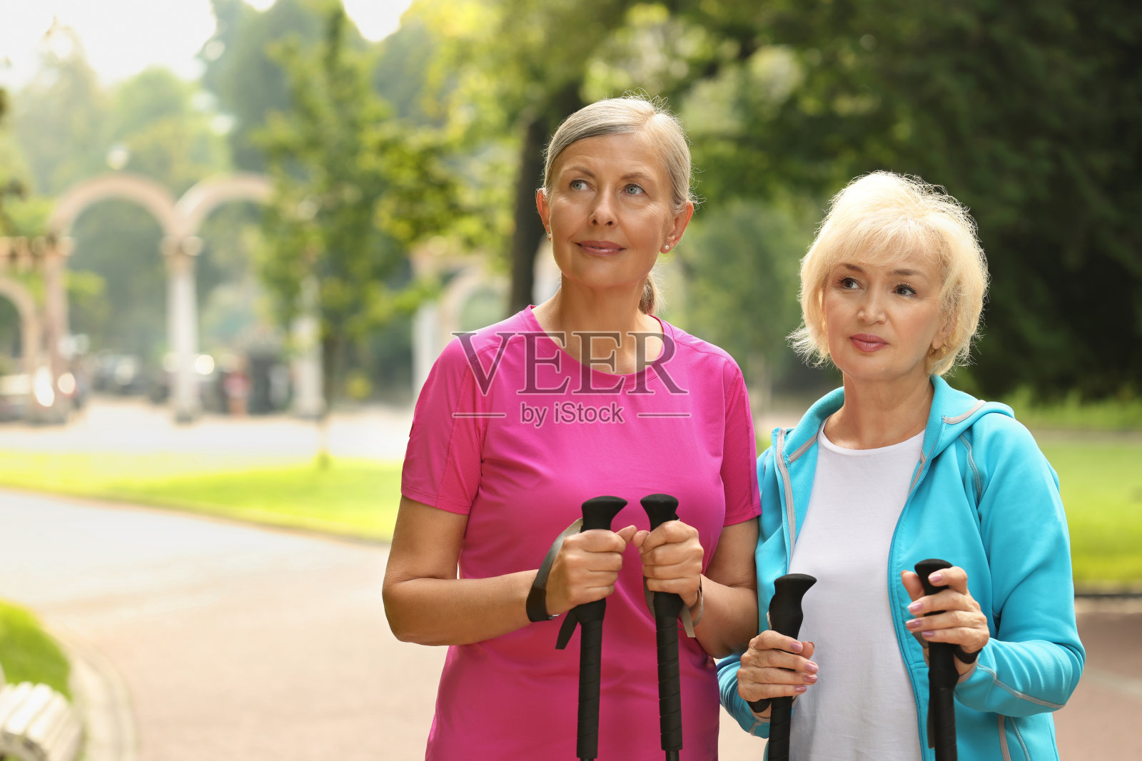两个老年妇女在户外拄着北欧步行杆，给文字留出空间照片摄影图片