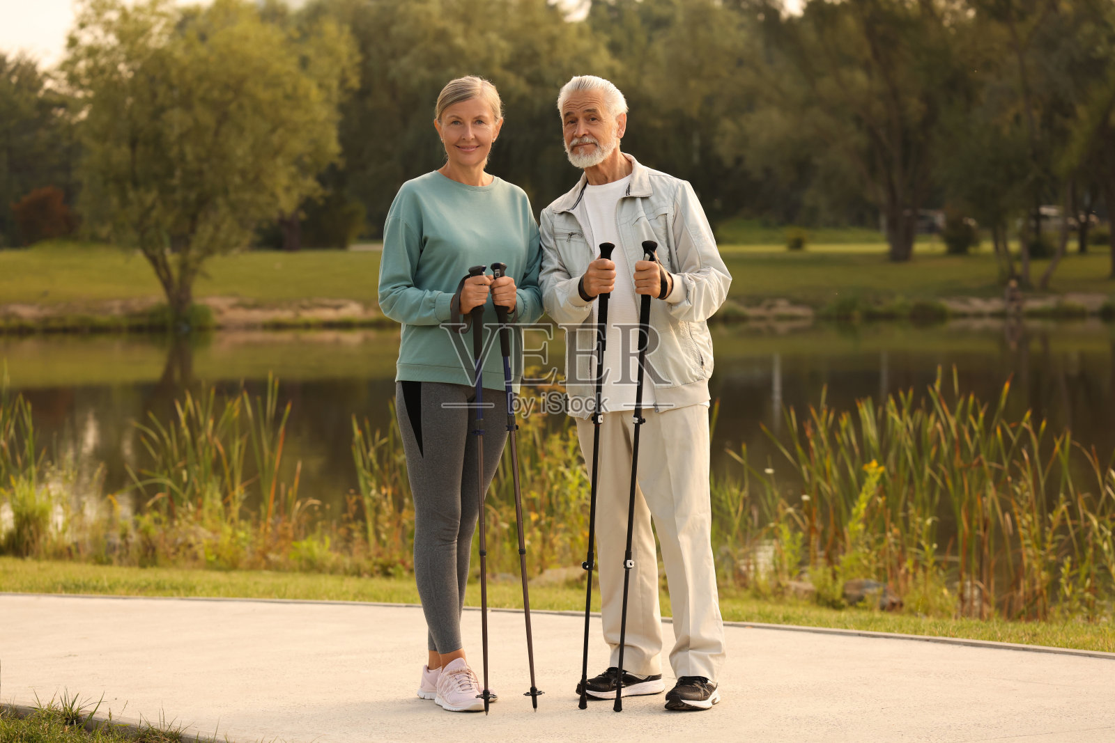 一男一女在户外拄着北欧步行杖照片摄影图片