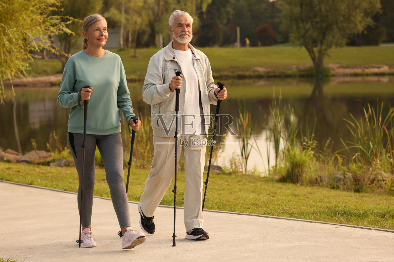 老年男女在户外表演北欧步行，为文字留出空间照片摄影图片