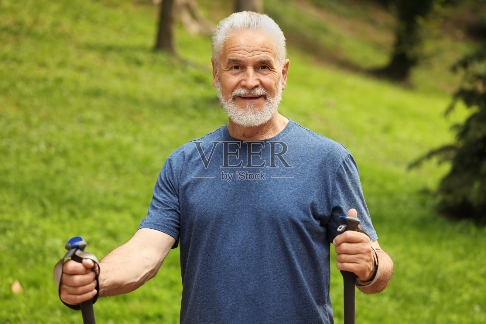在户外拄着北欧步行杆的老人照片摄影图片