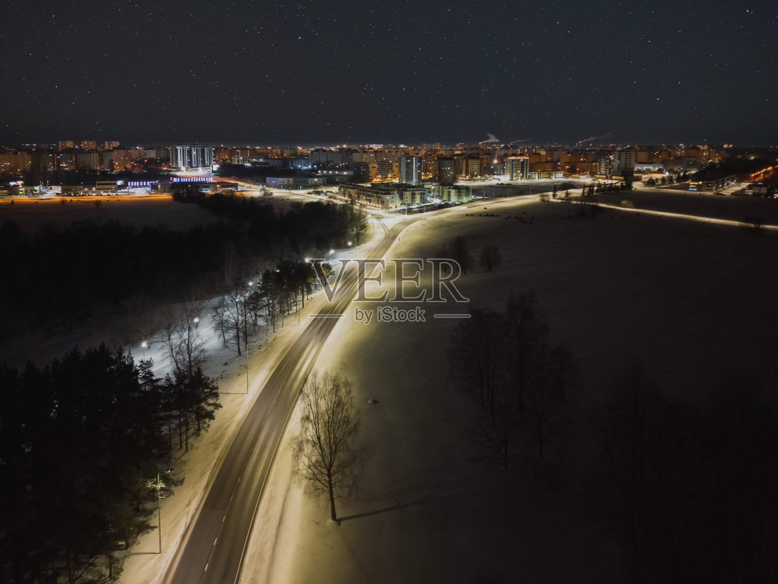 夜景，无人机照片。通往Lasnamae地区的道路上，这座城市在黑暗的星空中闪闪发光。照片摄影图片
