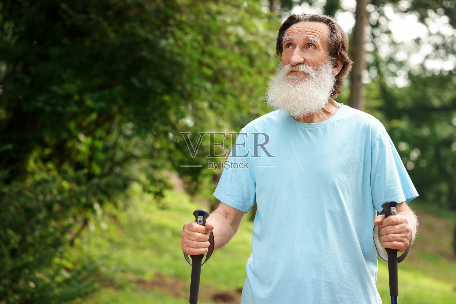 老人在户外拄着北欧步行杆，给文字留出空间照片摄影图片