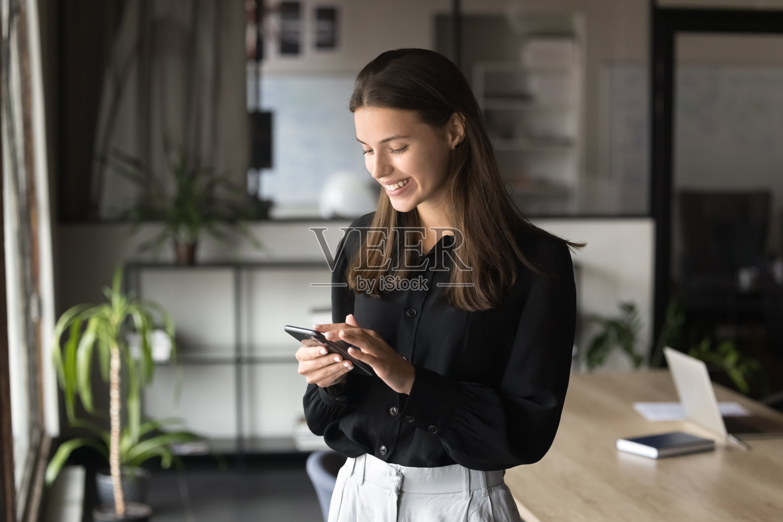 开朗美丽的女商人在智能手机上打字，使用专业服务照片摄影图片