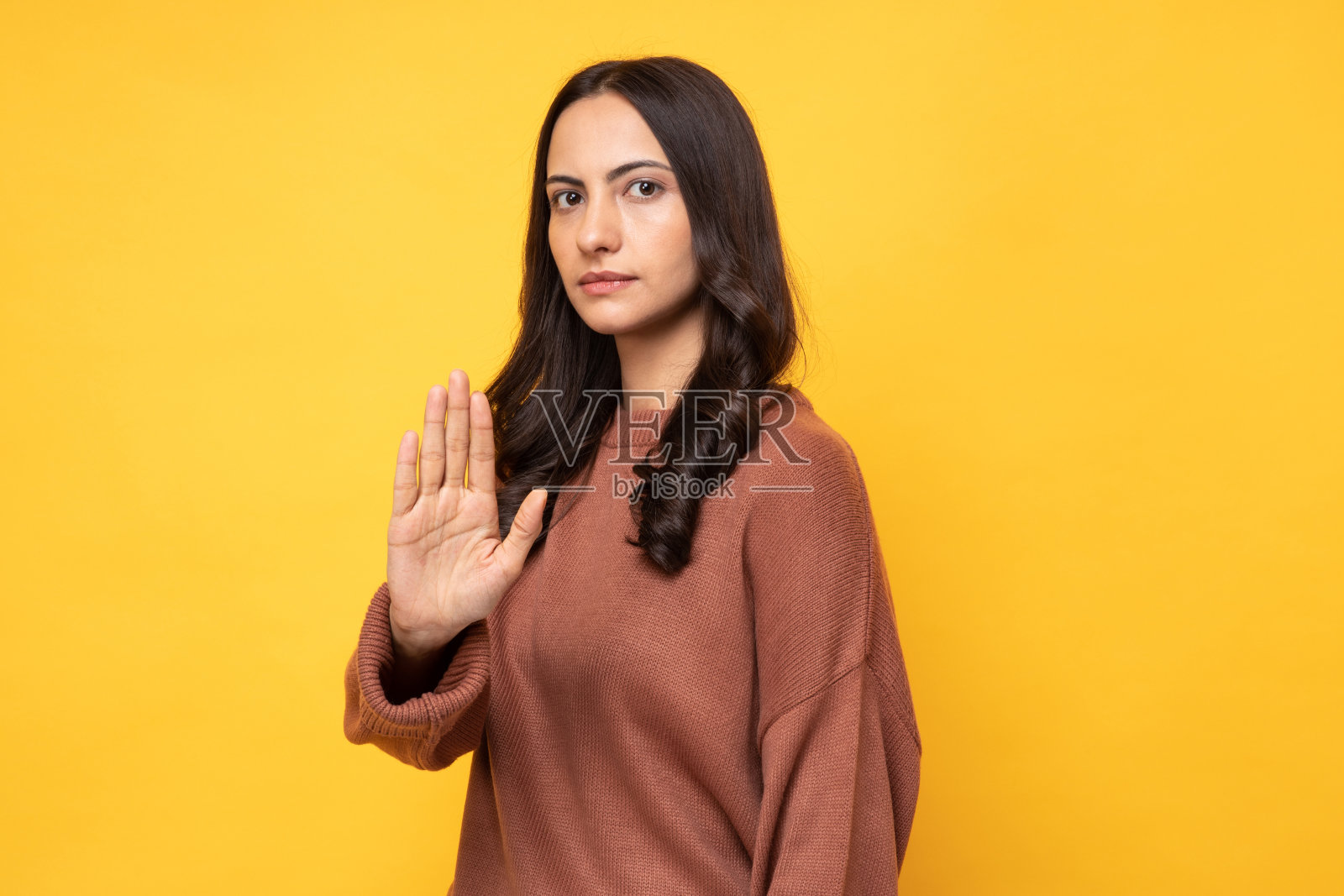 照片的年轻妇女在冬天穿站在黄色背景股票照片照片摄影图片