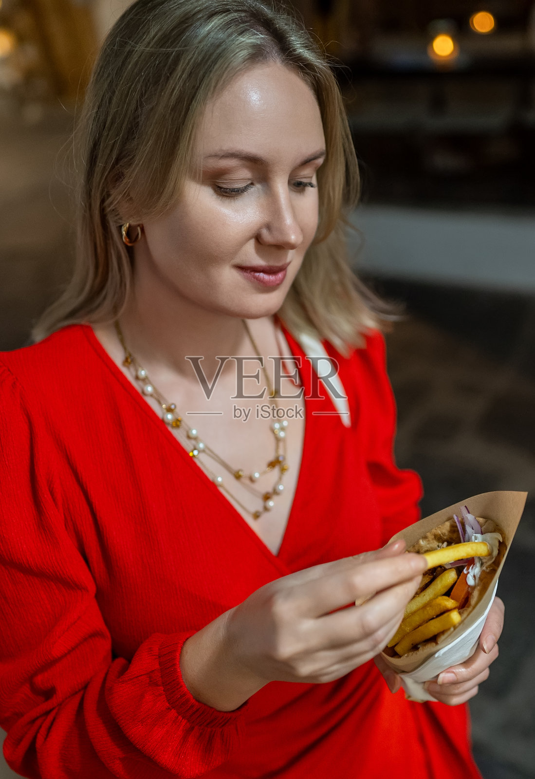 女人吃皮塔饼配薯条。照片摄影图片