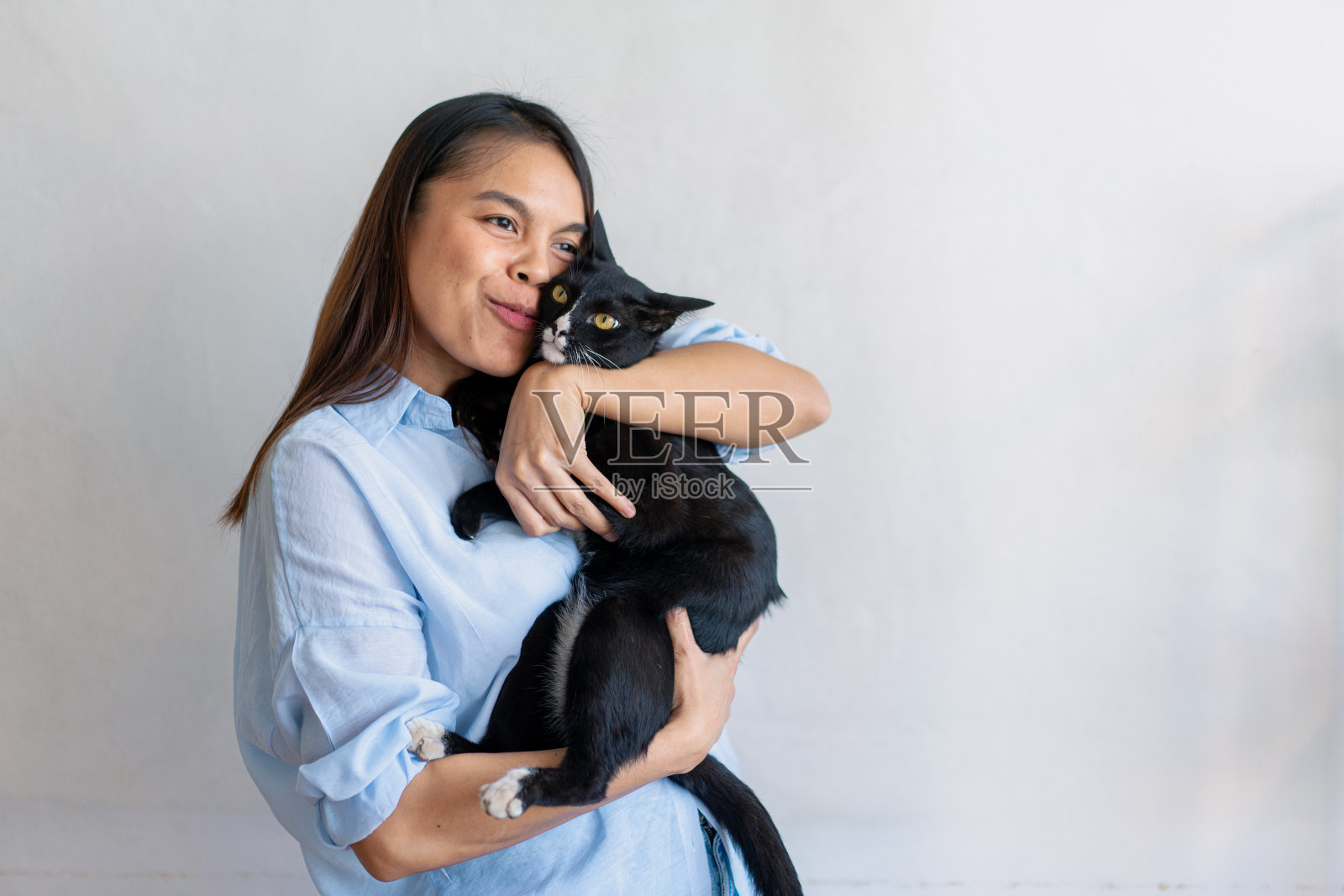 秋天的一天，快乐健康的女人坐在客厅里和可爱的猫玩耍，友谊和对宠物的爱。照片摄影图片