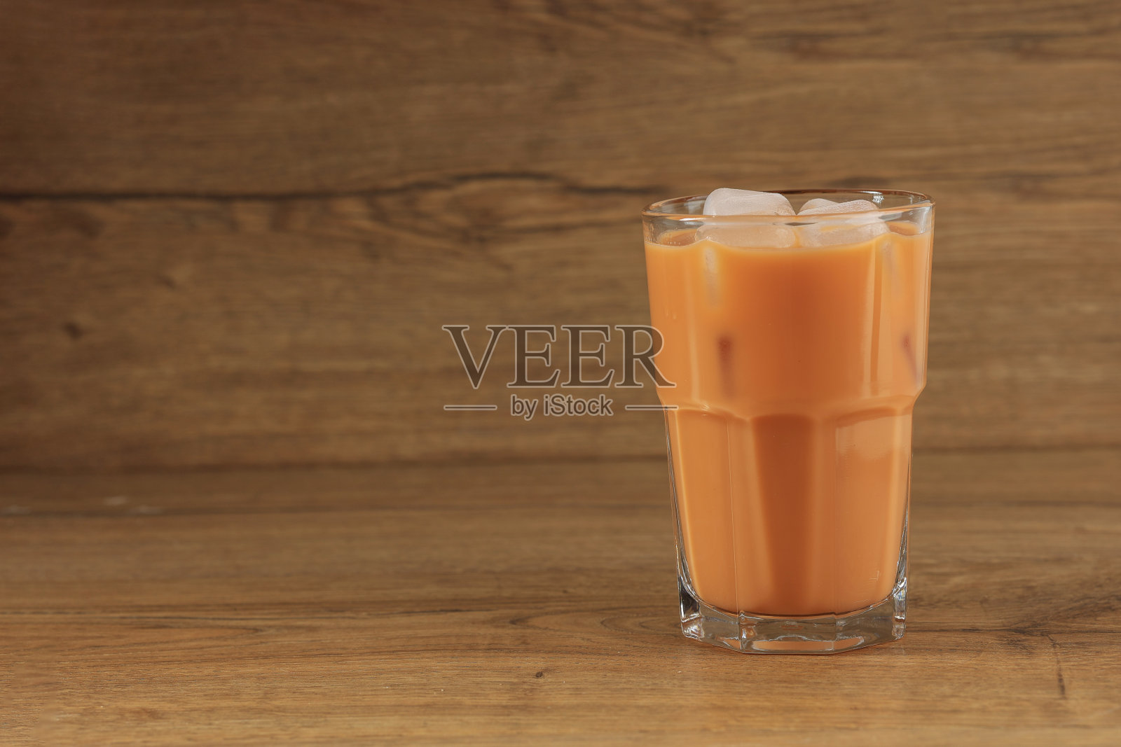 木桌上一杯冰泰国奶茶照片摄影图片