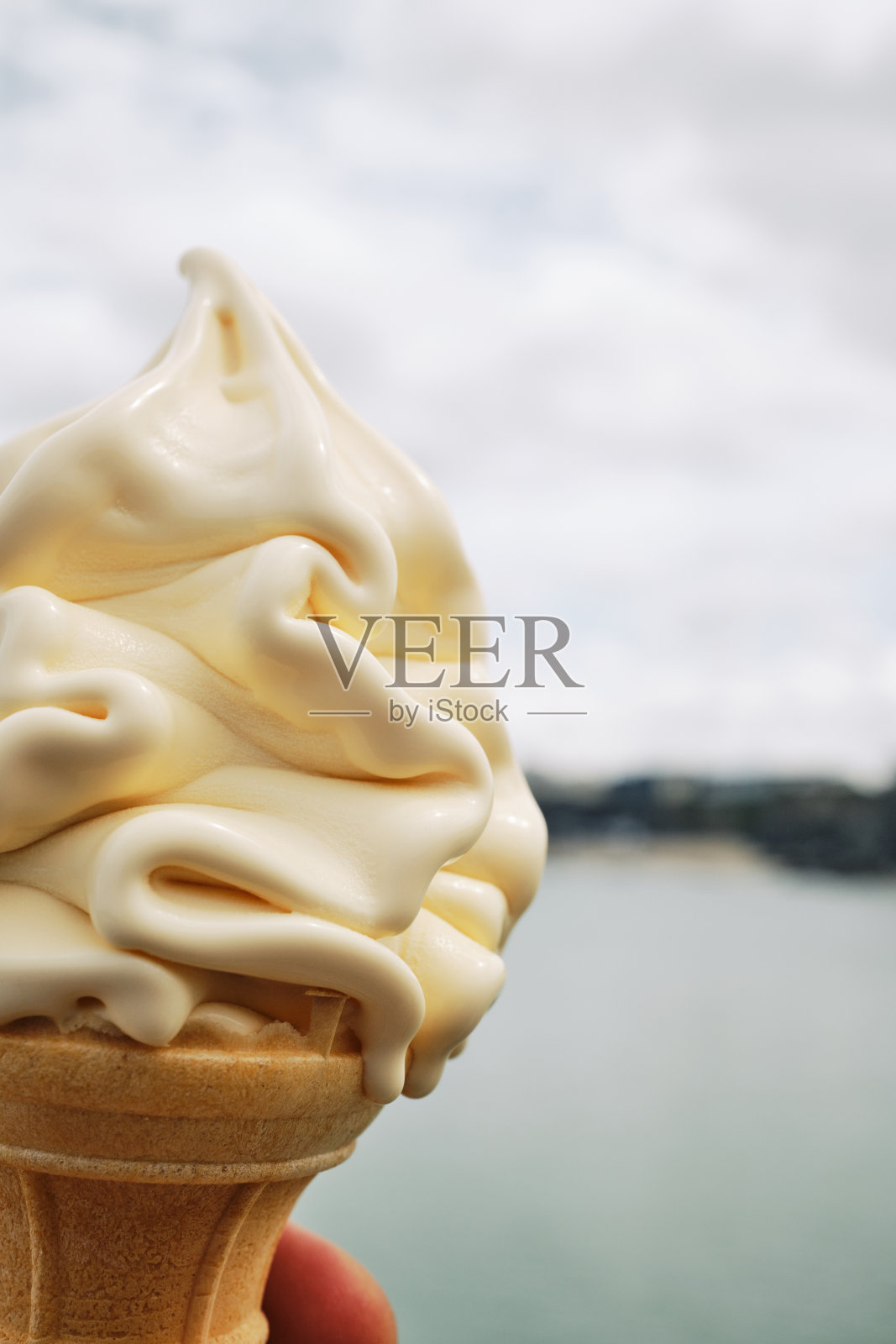6月的一天，英国康沃尔郡纽基海岸，香草软冰淇淋甜筒的镜头。照片摄影图片