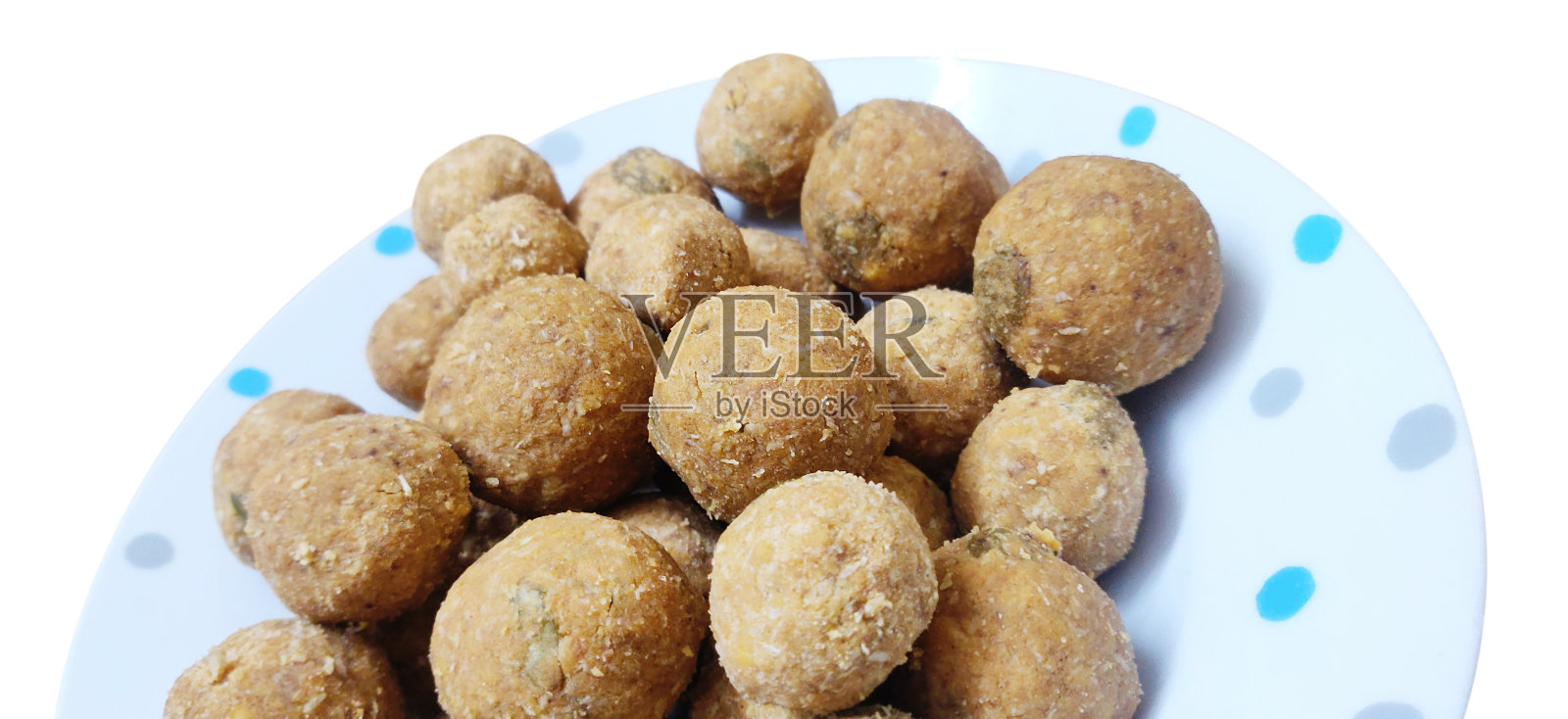 剪出的全景图片，一堆自制的aata laddoo或aatta ladus或印度pinni mithai镀在一个点状的白色盘子或碗孤立在白色背景照片摄影图片