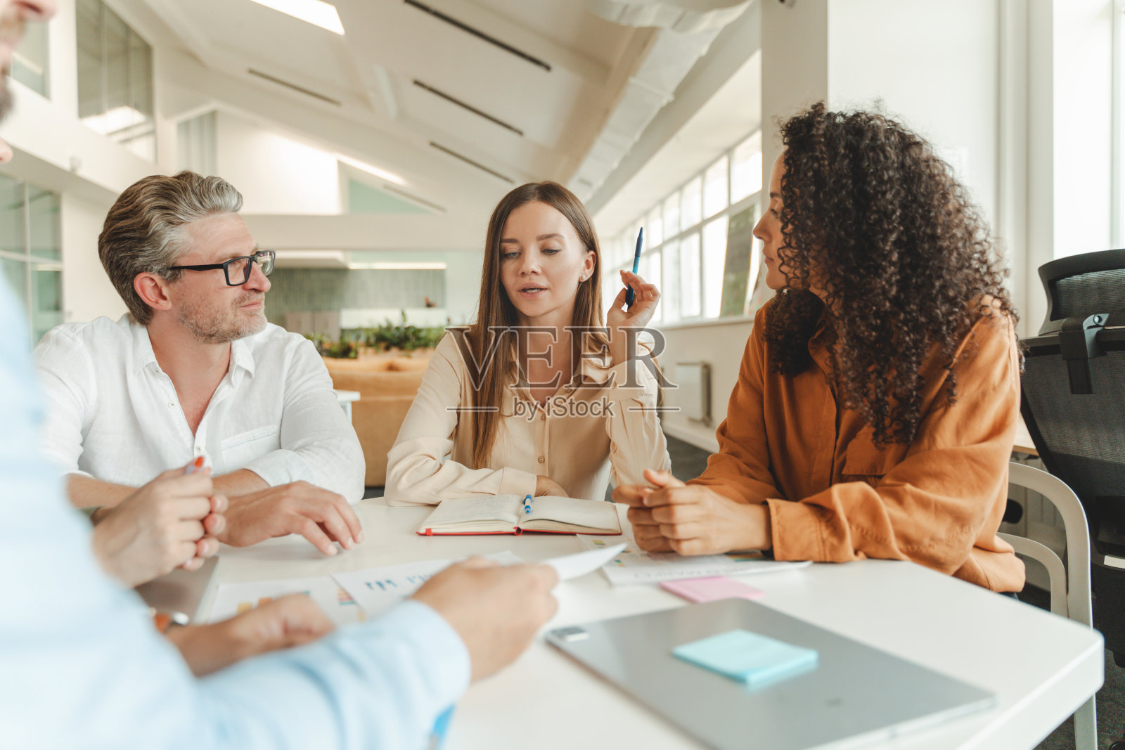 自信的女商人坐在工作场所与同事一起工作，头脑风暴，分享想法照片摄影图片