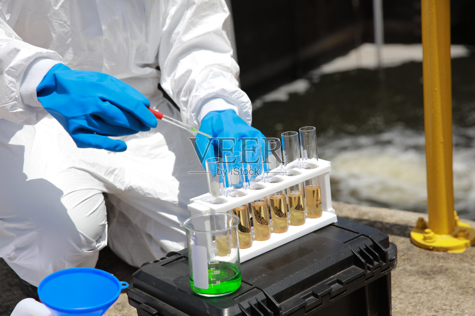 水分析操作员穿戴PPE取样并审核来自水处理厂的水，工业和环境概念照片摄影图片