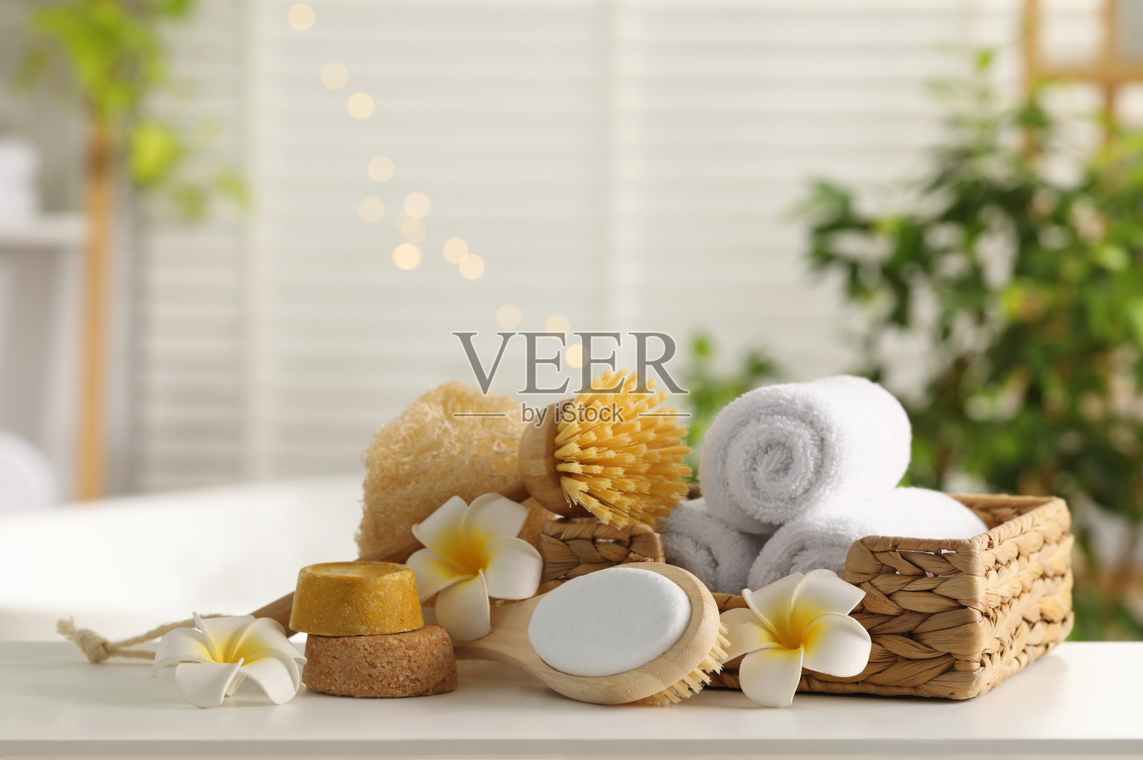 浴室白色桌子上不同的水疗产品和鸡蛋花组成照片摄影图片