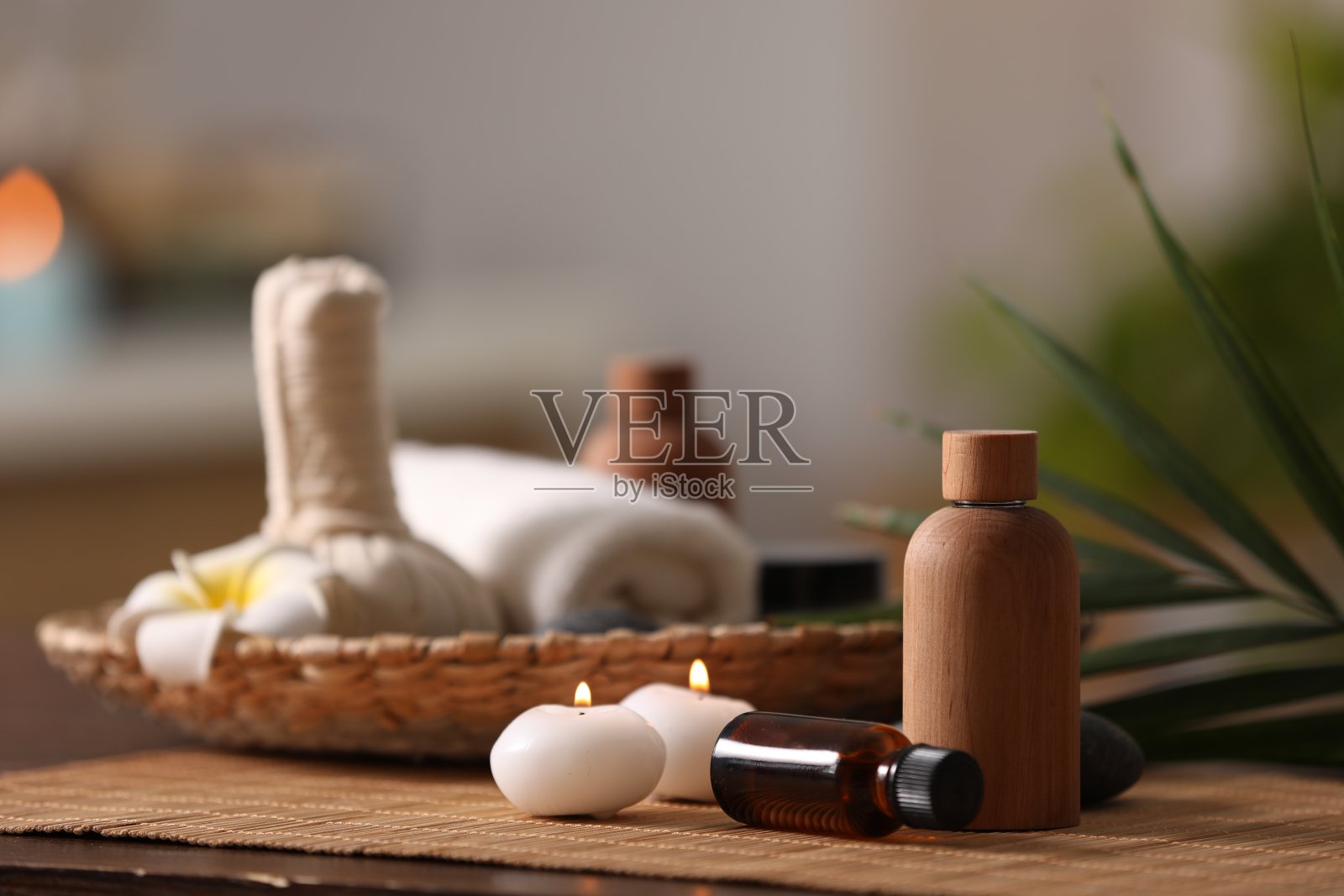 在模糊的背景下，不同的水疗产品和燃烧的蜡烛在木桌上组成，为文字留出空间照片摄影图片