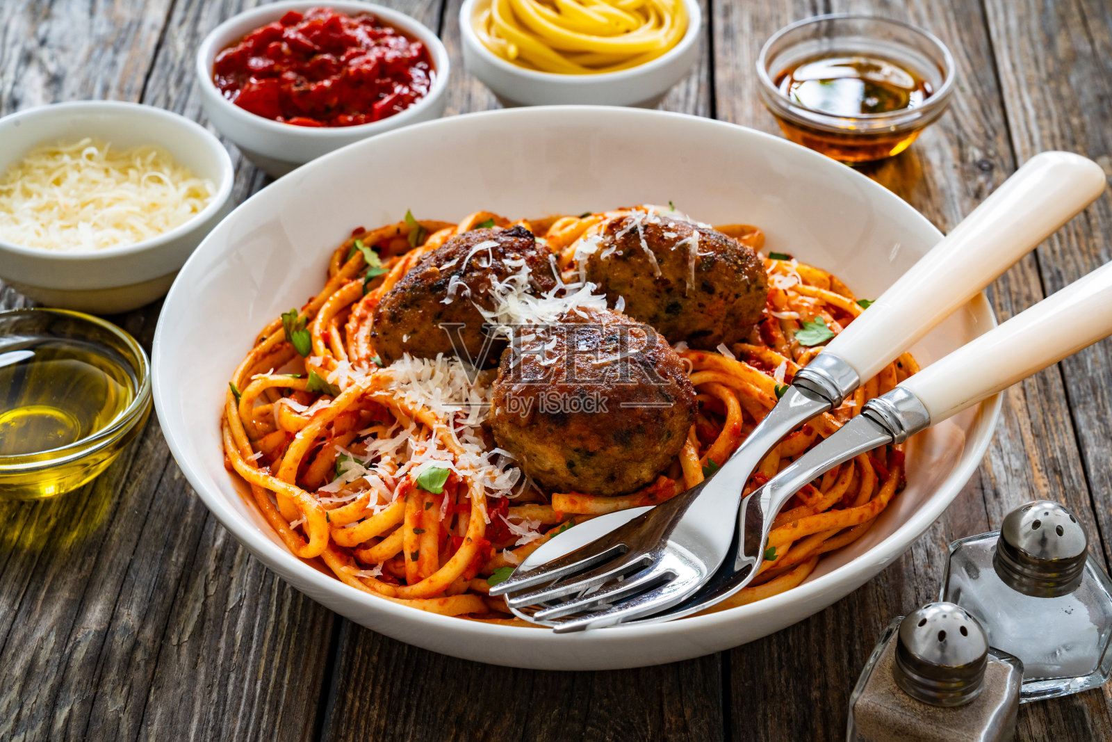 木桌上的番茄酱肉丸意大利面照片摄影图片