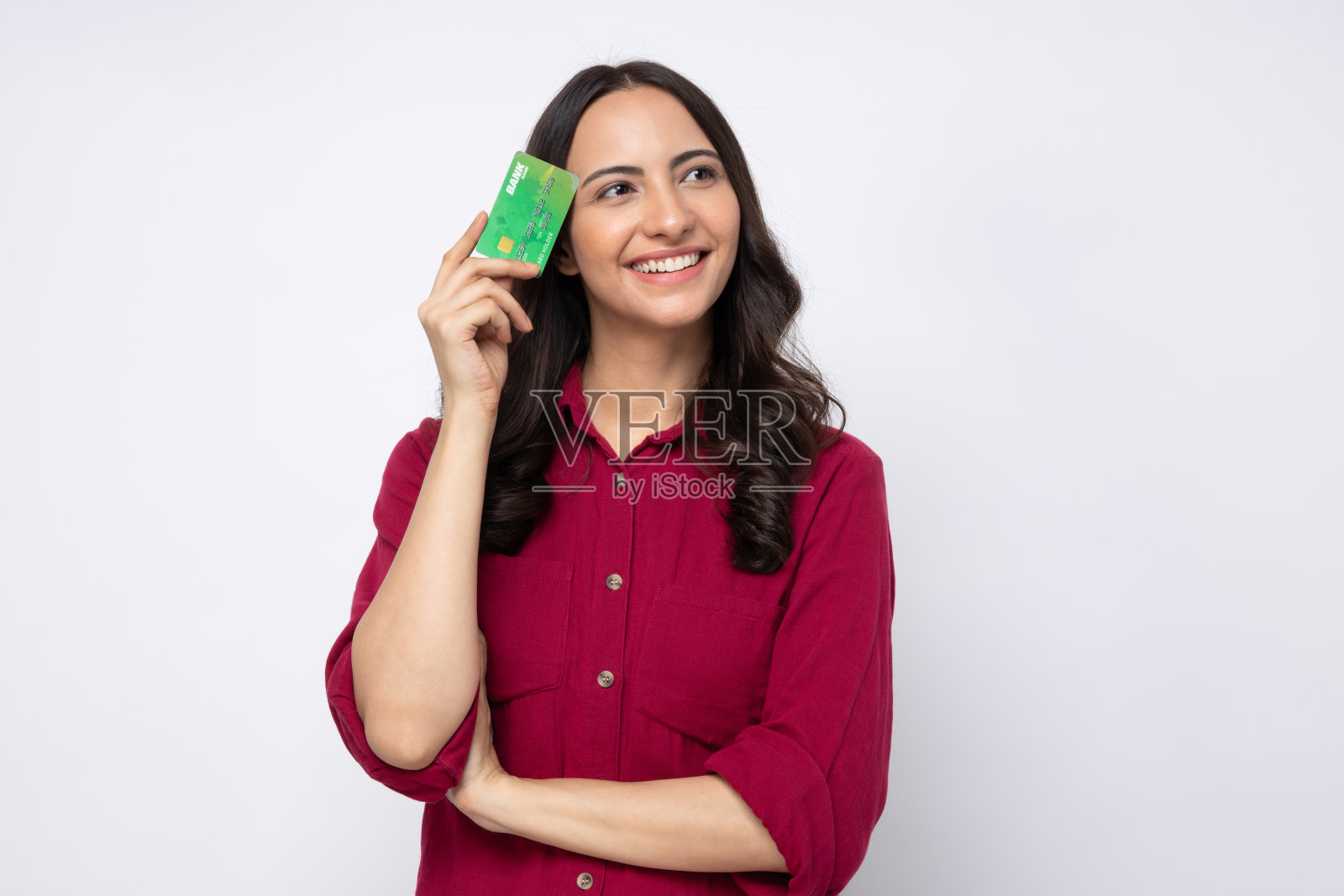 开朗的女孩穿着衬衫的肖像拿着塑料银行卡购物付款孤立在白色背景股票照片照片摄影图片