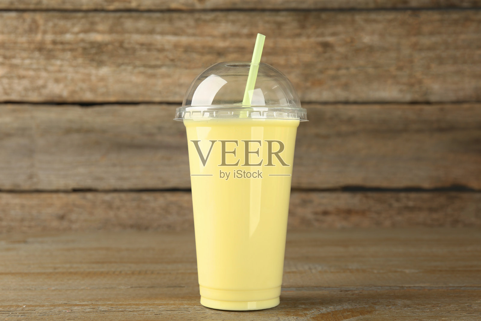 木桌子上的塑料杯美味的冰沙照片摄影图片