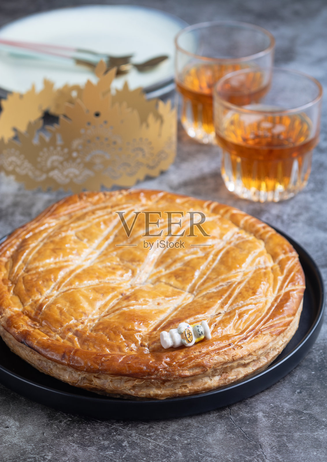 一个传统的法国国王蛋糕，放在盘子里，上面有陶瓷娃娃或芙蒂芙照片摄影图片