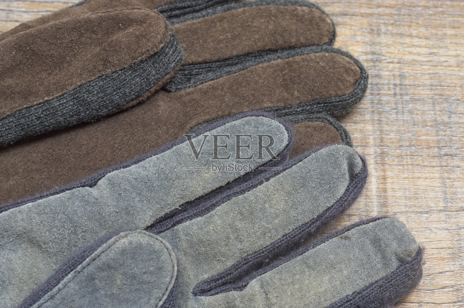 两只不同颜色的手套放在一块木板上照片摄影图片