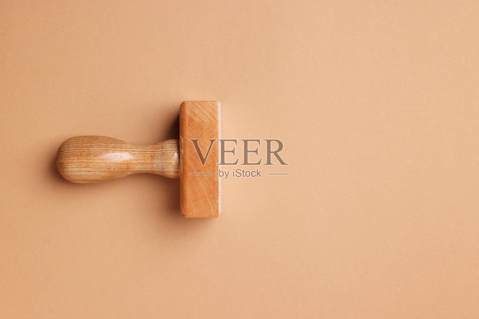 一个木制邮票工具在浅棕色的背景，俯视图。文本空间照片摄影图片