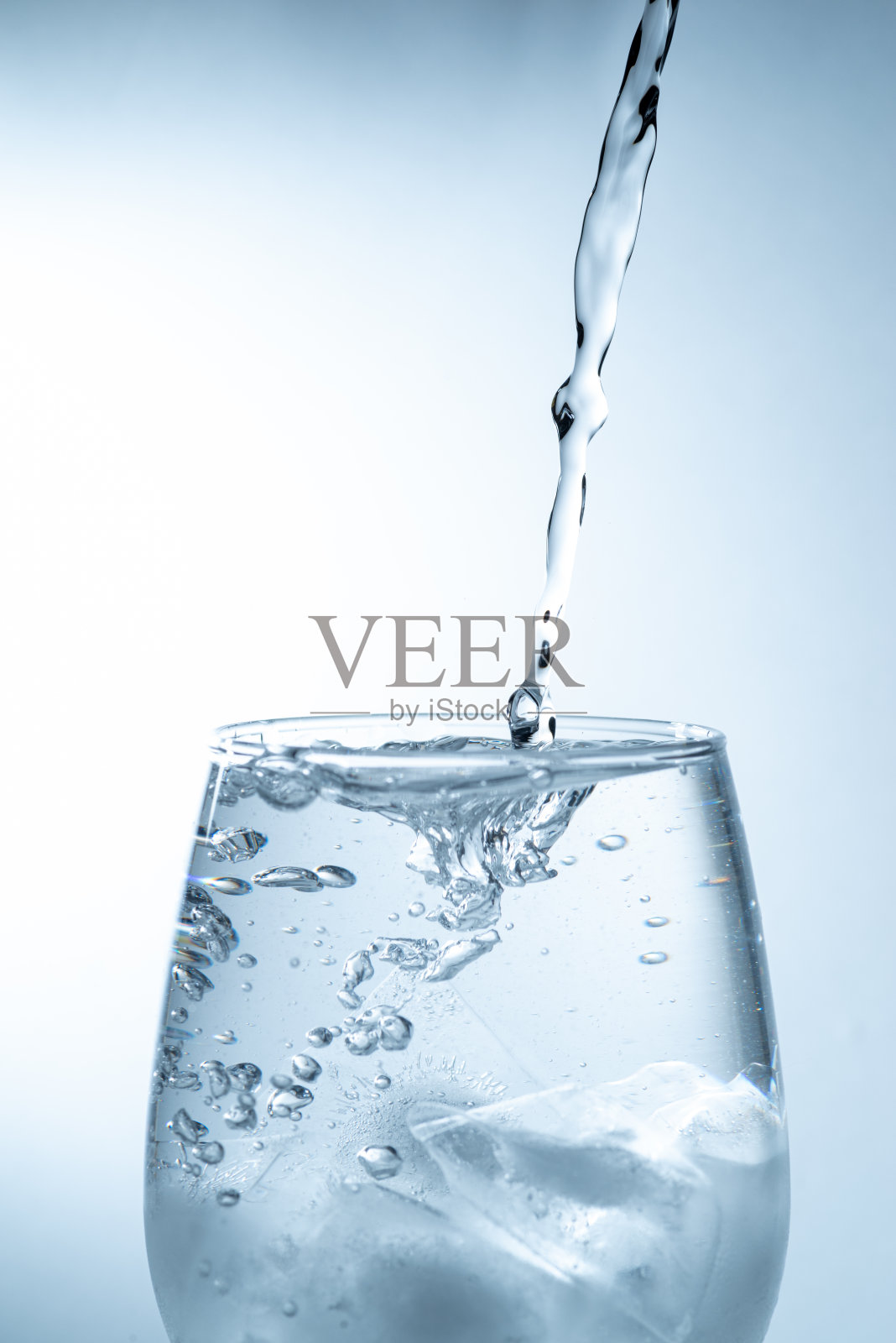 把水倒进杯子里照片摄影图片