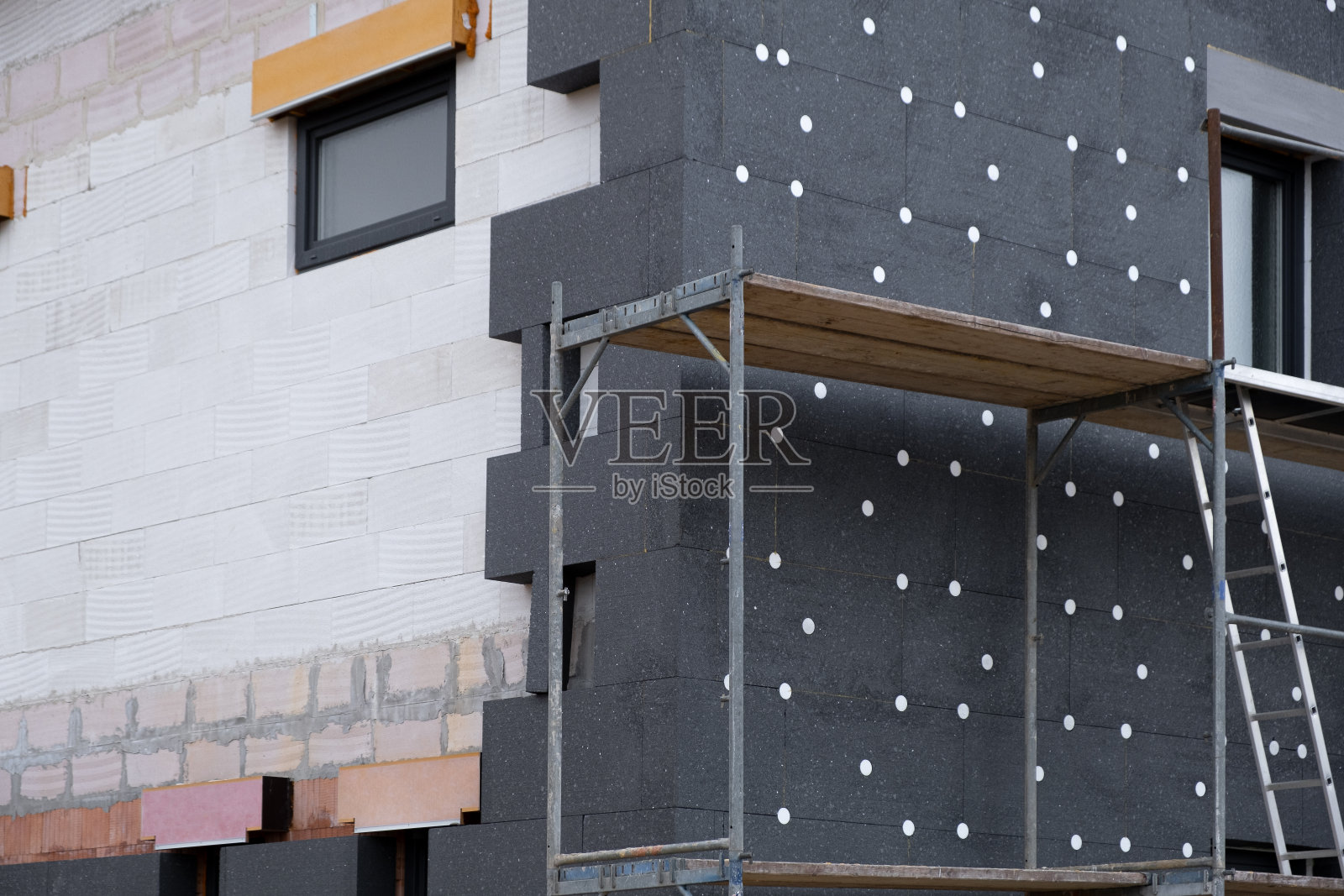 现代保温材料。在施工过程中新建房屋的外墙多层保温。照片摄影图片