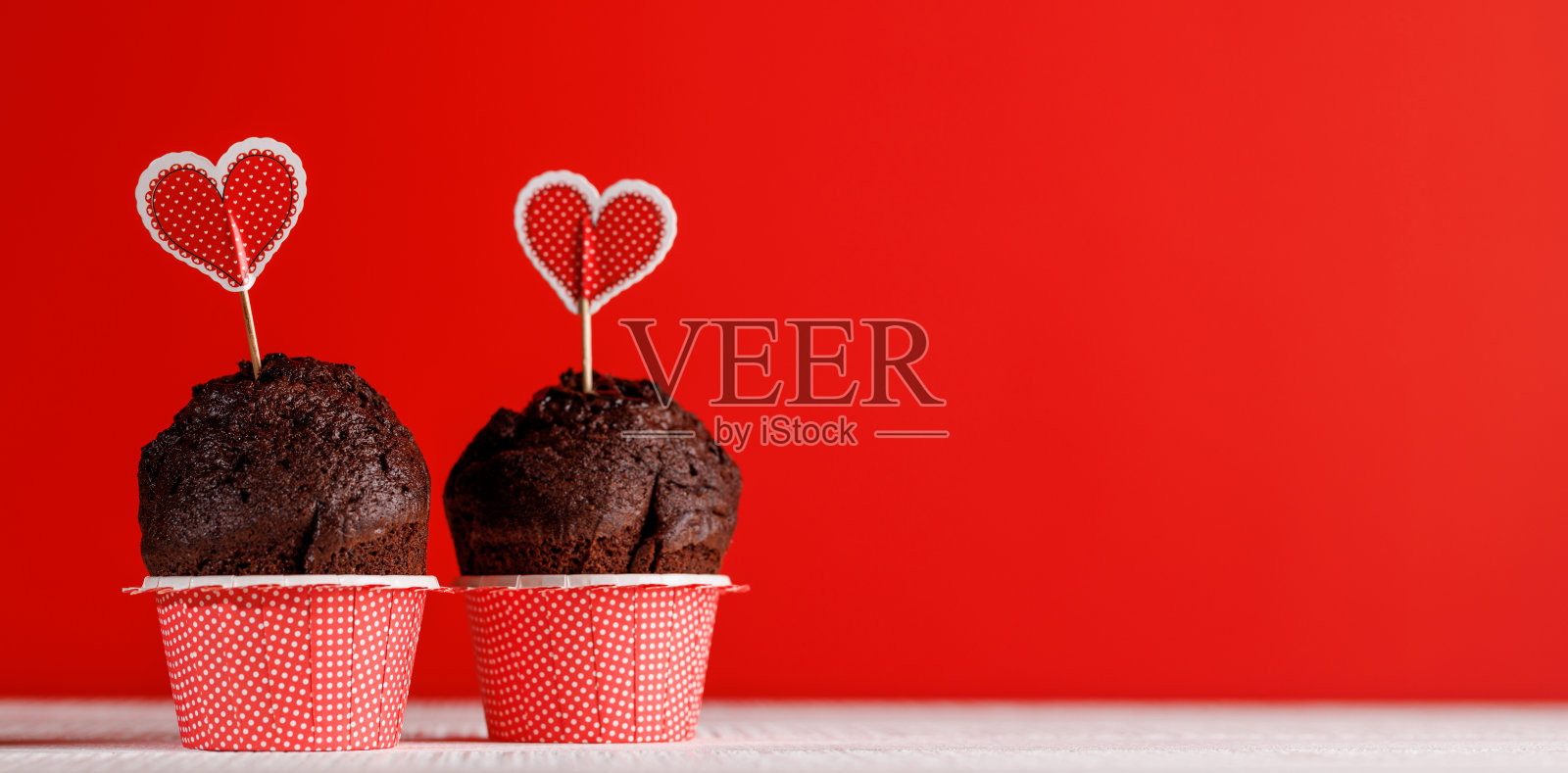 小蛋糕之爱:充满活力的红色背景上的爱心主题点心照片摄影图片
